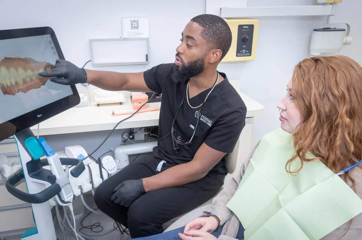 Dr. Charles White reviewing a restoration plan with a patient on the chairside monitor