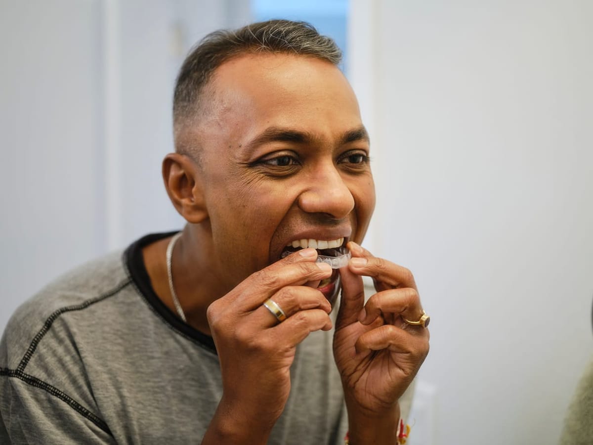 A patient fitting a custom oral splint used to relieve TMJ pain