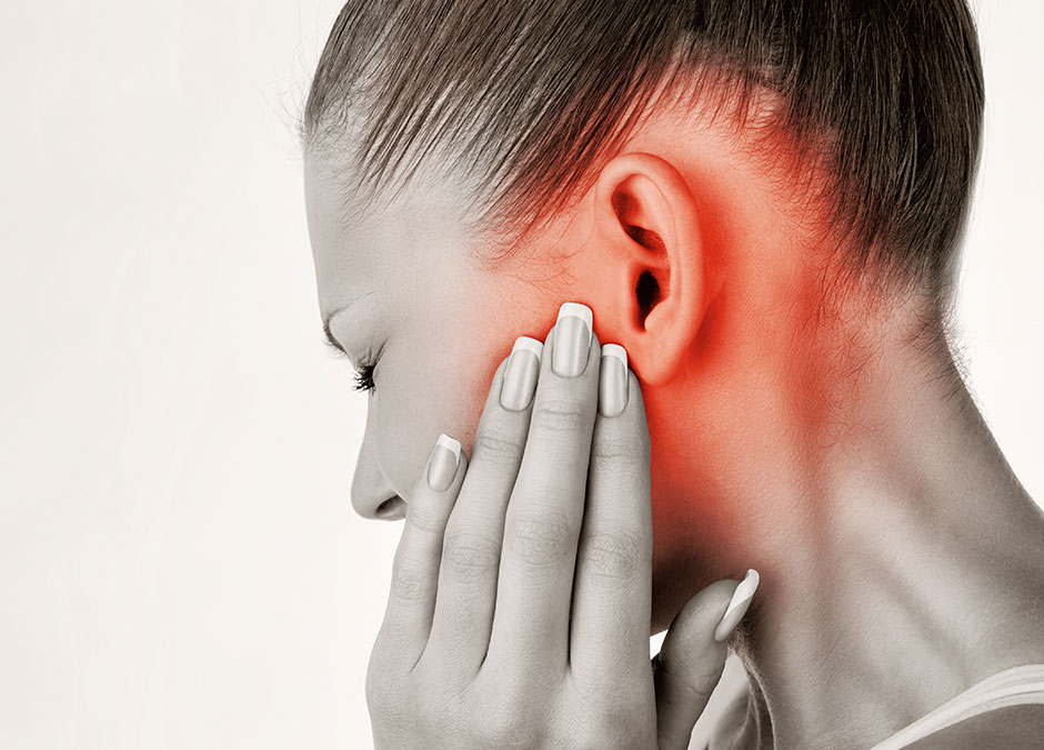 A patient holding their ear, showing where TMJ pain radiates