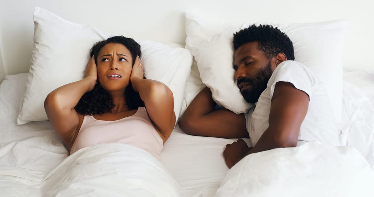 A couple in bed, one kept awake by their partner’s snoring