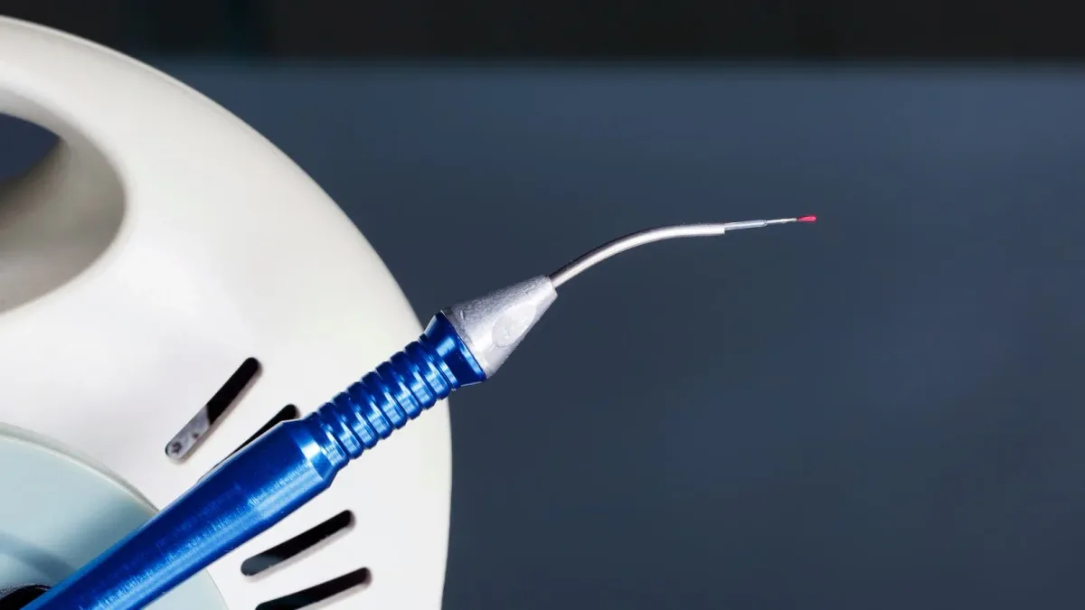 A dental laser handpiece on a sterile tray