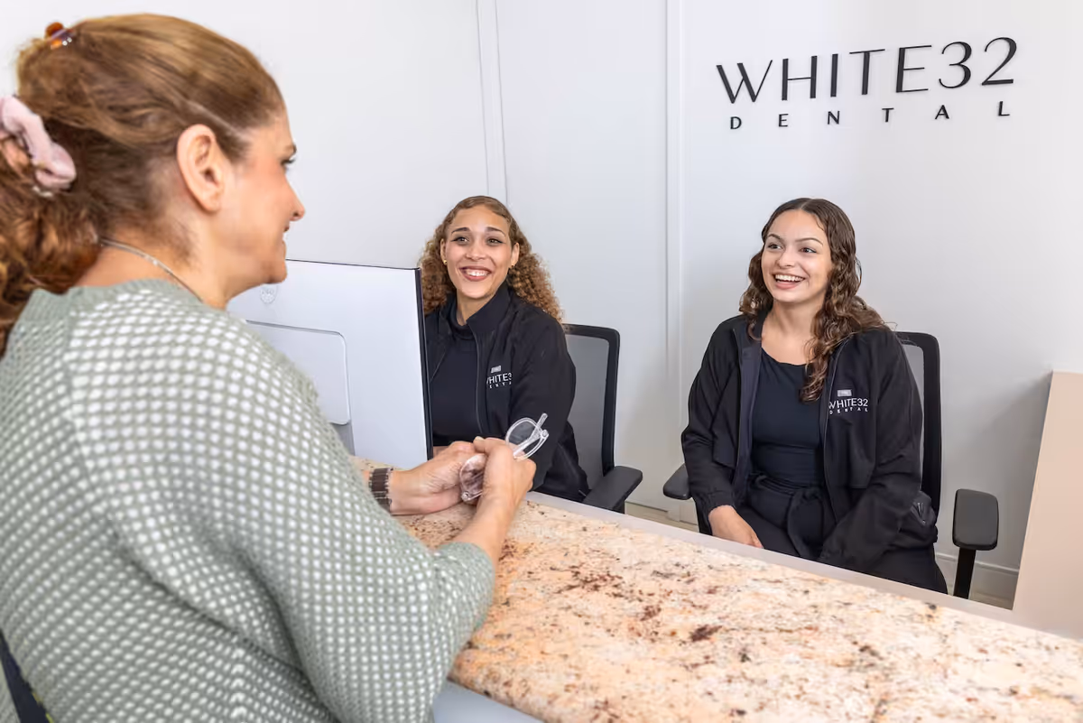 The White32 Dental front desk team welcoming a patient at Foxhall Square