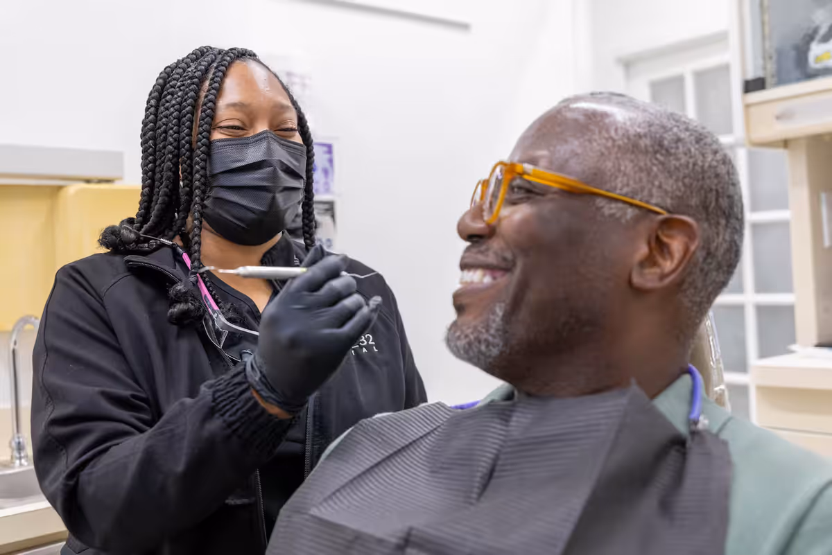 A White32 Dental hygienist cleaning a patient’s teeth in Foxhall Square